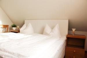 奥斯特巴德里克"Im Seewind"的白色的床、白色床单和枕头