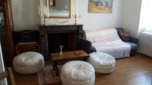 图尔尼TOURNUS Belle maison vue sur Saône的客厅配有沙发和两把脚凳