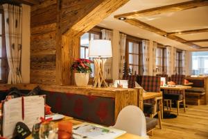 奥伯斯特多夫Familien- und Wellnesshotel "Viktoria"的餐厅设有木墙、桌子和灯