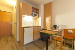 斯特拉斯堡斯特拉斯堡城市公寓的一间带桌子和冰箱的小厨房