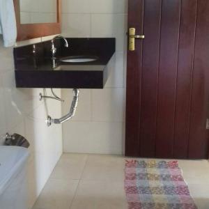 瓦尔任博尼塔Pousada Recanto do Sossego- Serra da Canastra的一间带水槽、镜子和门的浴室