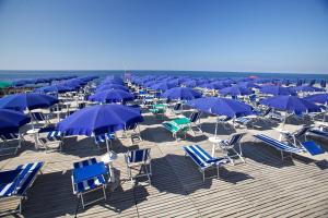 Torre InserraglioCasa Vacanze Torre Inserraglio的沙滩上的一把椅子和蓝色遮阳伞