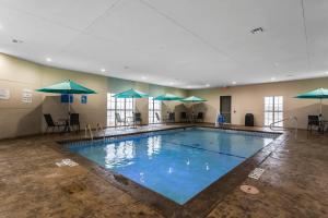 拉伯克Comfort Suites - University的大楼内带遮阳伞的大型游泳池