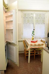 萨沃纳Relax e mare的厨房配有桌子、桌子和冰箱。