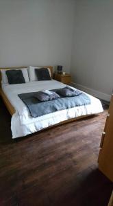 Slamannan避风港度假屋的卧室内的一张床位,铺有木地板