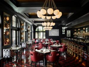 圣巴巴拉凯丽佛润酒店的餐厅设有红色的桌椅和吊灯