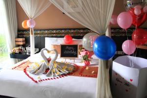 塞米亚克伽拉米别墅酒店的一间卧室配有气球和一张带蛋糕的床