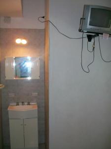 米娜克拉韦罗Hosteria Columbia的一间带水槽的浴室和墙上的电视
