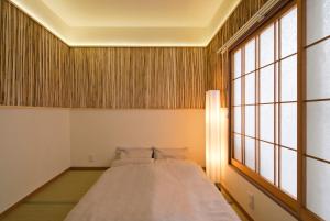 横滨Lucy's House横浜中華街 House3的一张大床,位于带大窗户的房间里