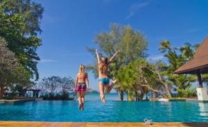 象岛Barali Beach Resort & Spa的两个女孩跳进度假村的游泳池