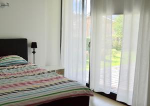NasvaHärmati Holiday House的卧室配有滑动玻璃门旁边的床