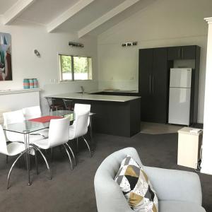 新普利茅斯Ratanui Villas的厨房以及带沙发和桌子的客厅。