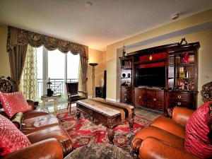 克利尔沃特Aqualea 504的客厅配有皮革家具,大型娱乐中心
