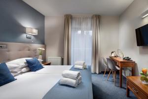 索波特Hotel Aqua Sopot的配有一张床和一张书桌的酒店客房