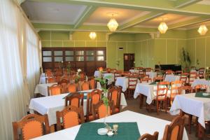 索瓦塔Hotel Hefaistos - Sovata的用餐室配有桌椅和白色的桌布