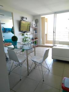 阿尔加罗沃Costa Algarrobo Norte的客厅配有玻璃桌和椅子