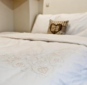 布达佩斯Green Apartment的白色的床,上面有红心的白色床罩