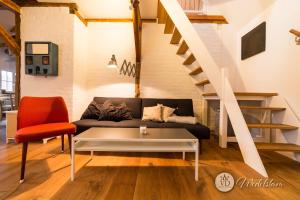莱比锡Villa Dohna - Apartment Wedelstam的带沙发和楼梯的客厅