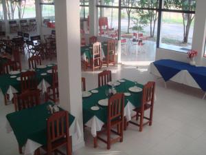 Ypacarai鲁塔太阳海岸酒店的一间设有绿色和白色桌椅的用餐室