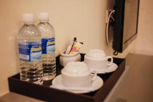 怡保艺术小屋酒店的托盘,装有两瓶水和杯子