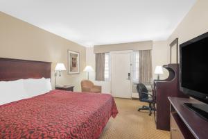 斯普林菲尔德普林菲尔德/费城戴斯酒店的酒店客房配有红色的床和平面电视。