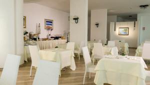 维耶斯泰塞拉拉酒店的用餐室配有白色的桌子和白色的椅子
