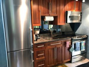 North Shore VillageFrognal Apartment的厨房配有木制橱柜和不锈钢冰箱。