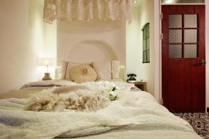 抱川市罗塞托酒店的卧室配有白色的床和红色的门