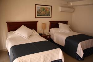 巴亚尔塔港巴亚尔塔港阿雷格里港酒店的两张位于酒店客房的床,配有两张sidx sidx单人床