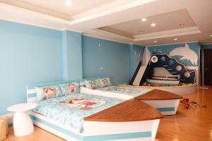 安平区吾宅溜滑梯亲子民宿 的一间卧室配有一张蓝色墙壁的床