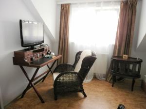 弗克拉布鲁克松鸡联排别墅酒店的一间房间,配有两把椅子和一张桌子上的电视