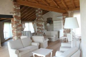 波佐伦戈雷莱斯蒙多泰拉乡村民宿的客厅配有白色家具和砖墙