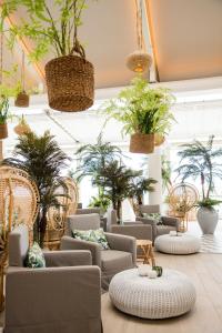 格兰高伯LUX* Grand Gaube Resort & Villas的一间房间,里面摆放着一堆椅子和盆栽植物