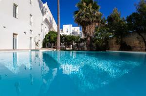 莱切莱切大酒店的一座大型蓝色游泳池,位于大楼旁边