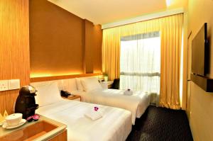 新加坡海佳大酒店的酒店客房设有两张床和窗户。