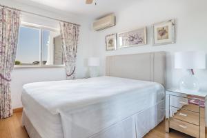 金塔湖Apartamentos Valverde - Quinta do Lago的白色的卧室设有床和窗户