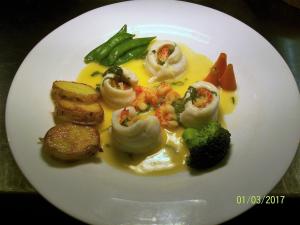 亚瑟斯通礼拜堂酒店的一份包含海鲜和蔬菜的白盘食品