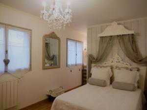 Réau拉科多讷瑞德利奥旅馆的卧室配有一张带吊灯的大型白色床。
