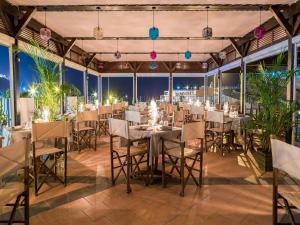库拉海滩Idyll Suites - Adults Only的用餐室配有桌椅和灯光