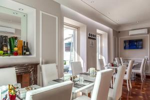 罗马Relais Trevi 95 Boutique Hotel的一间设有白色桌椅和壁炉的用餐室