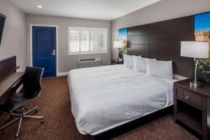 瓦列霍Vallejo Inn的一间卧室配有一张大床、一张桌子和一扇蓝色的门。