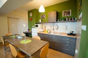 尼什Sweet Apartments and Rooms的厨房设有木桌和绿色的墙壁。
