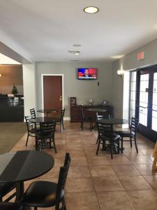 斯克内克塔迪Belvedere Inn Schenectady - Albany的一间在房间内配有桌椅的餐厅