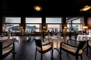 菲茨瑙湖畔露台酒店的用餐室设有桌椅和窗户。