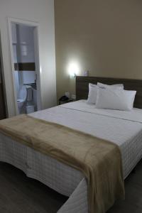 毛阿Hotel Infinity的卧室配有一张带白色床单和枕头的大床。