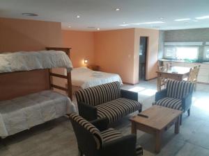 埃尔卡拉法特卡拉法特旅馆的一间卧室配有一张双层床、椅子和一张桌子