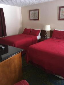 尼亚加拉瀑布安克尔汽车旅馆的两张位于酒店客房的床铺,配有红色床单