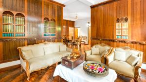 库玛拉孔Kumarakom Wood Castle Serviced Appartments的客厅配有两把椅子和一张桌子