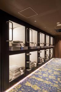 东京秋叶原格兰斯特胶囊旅馆的客房设有带镜子的多张双层床。