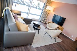 因特拉肯Apartment Anemone - GriwaRent AG的带沙发和电视的客厅